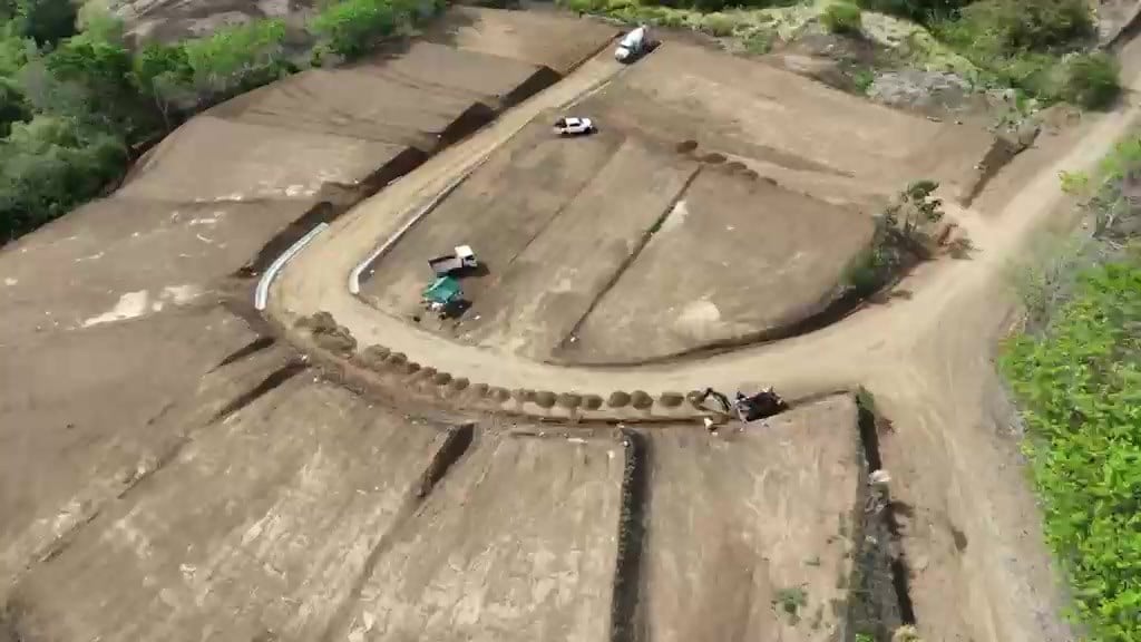 The road loop from above, with graded lots on either side and machinery at work