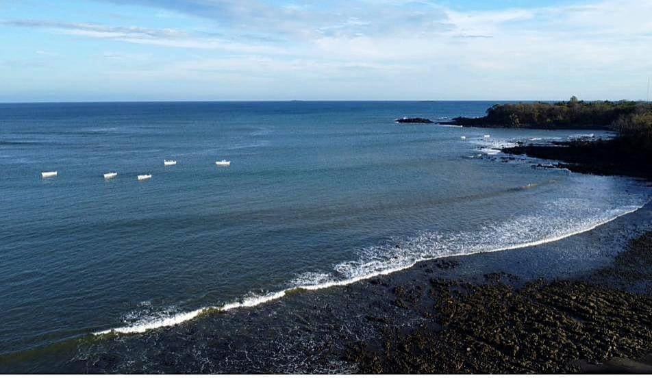The calm bay at El Ciruelo with small fishing boats offshore